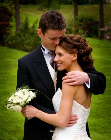 reportage wedding photograph of bride and groom cuddling in the grounds of Alverton Manor in Truro